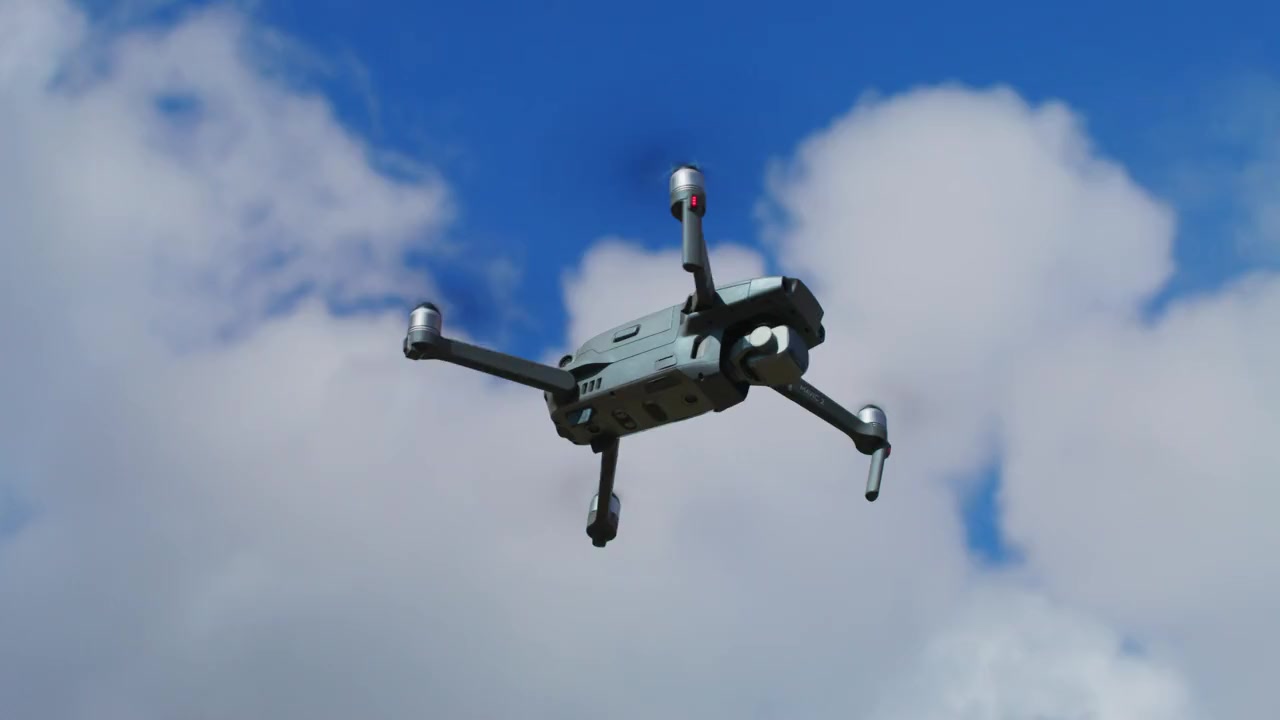 Drone flying and turning against a blue sky